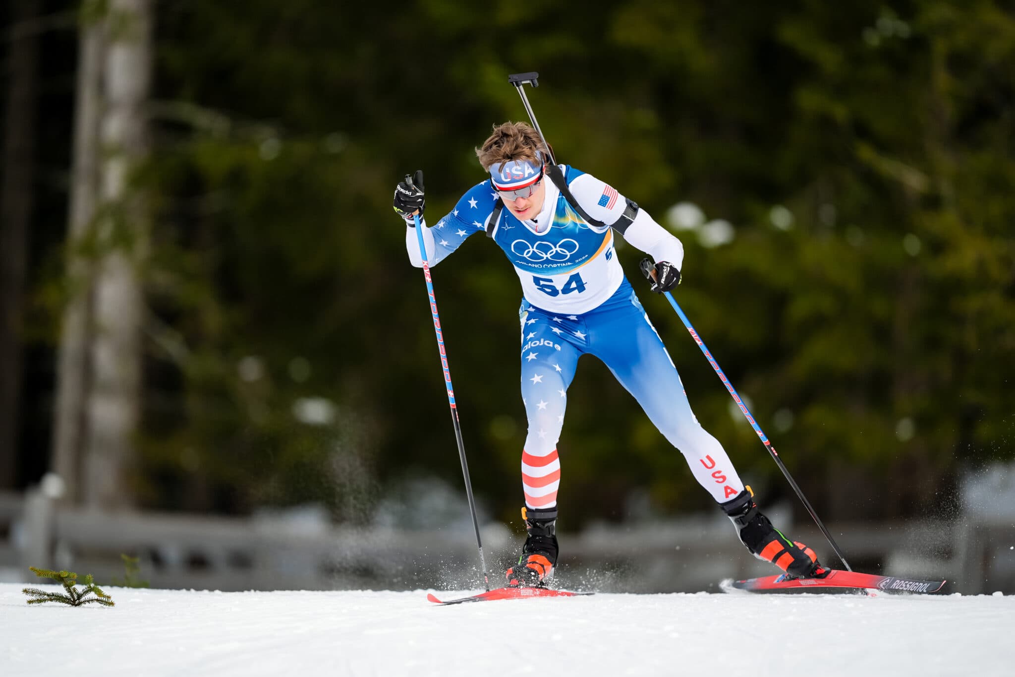 Campbell Wright of the United States skiing in the biathlon sprint, rifle on his back, at the Antholz Olympic venue.